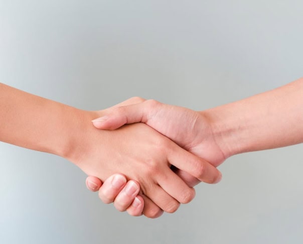 Duas pessoas a apertar as mãos, representando uma parceria com a Alertify