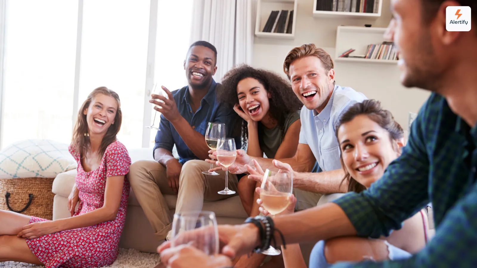 Grupo de amigos a rir com copos de vinho na sala de estar de um alojamento local