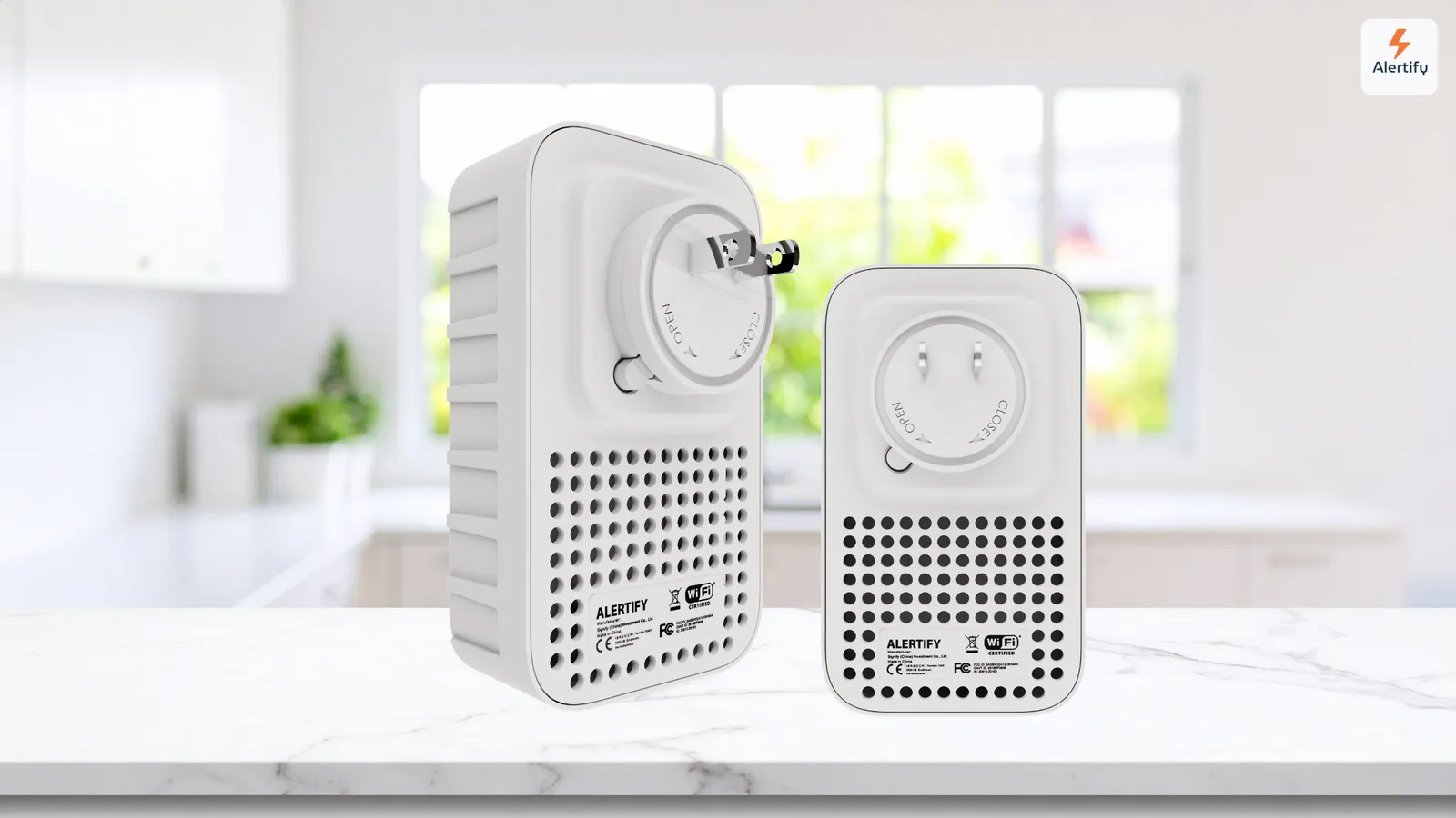 Dois dispositivos de monitorização da Alertify, o modelo maior próprio para exterior e o modelo mais pequeno para interior, lado a lado numa bancada de cozinha.