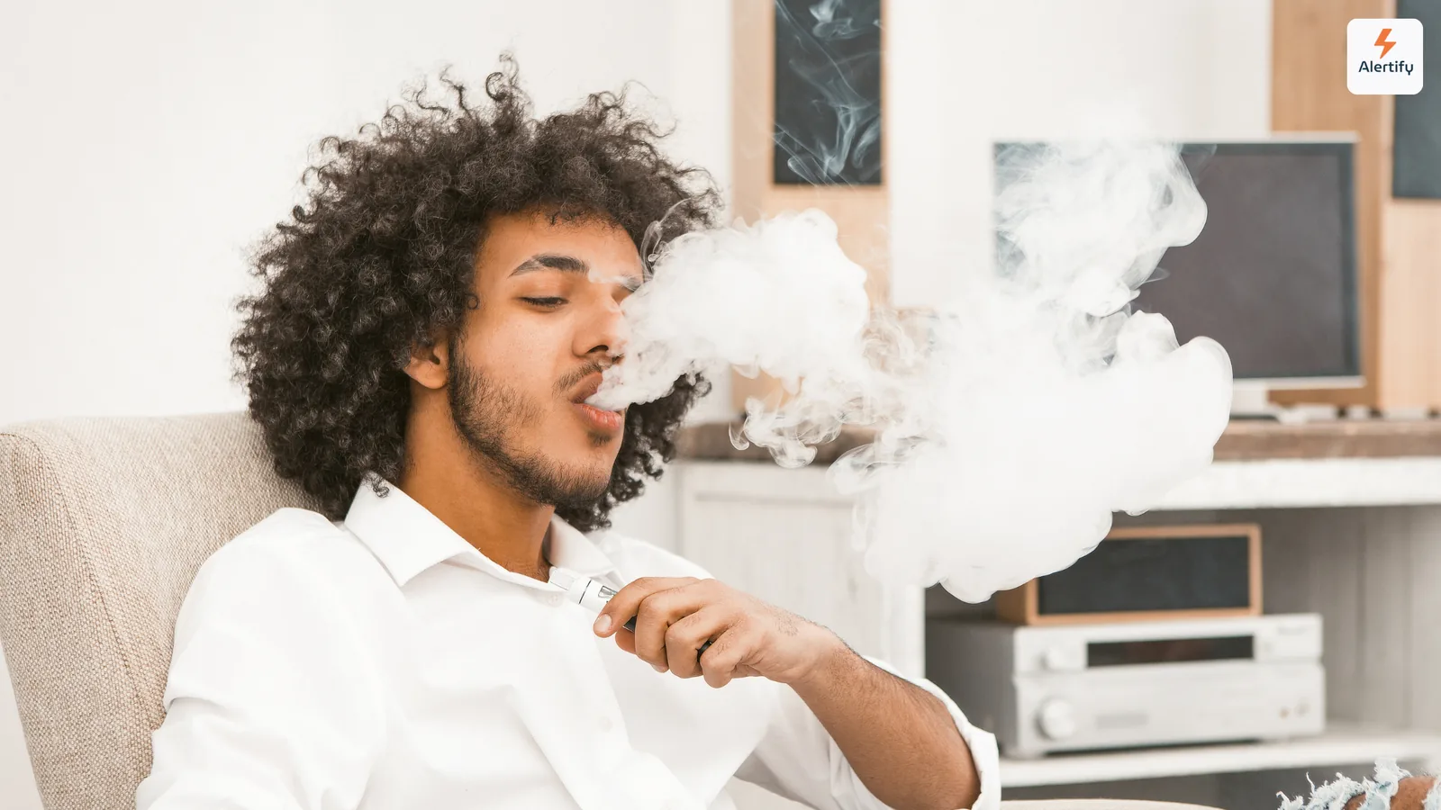 Hóspede a exalar uma densa nuvem de vapor sentado na sala de estar de um alojamento local